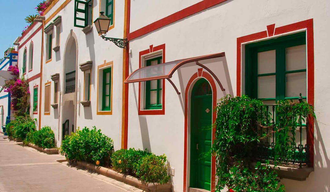 Pensilina con braccetti sopra una porta d'ingresso, in una via di paese